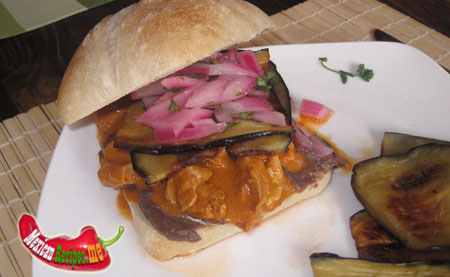 A plate with Mexican Torta and fried eggplants